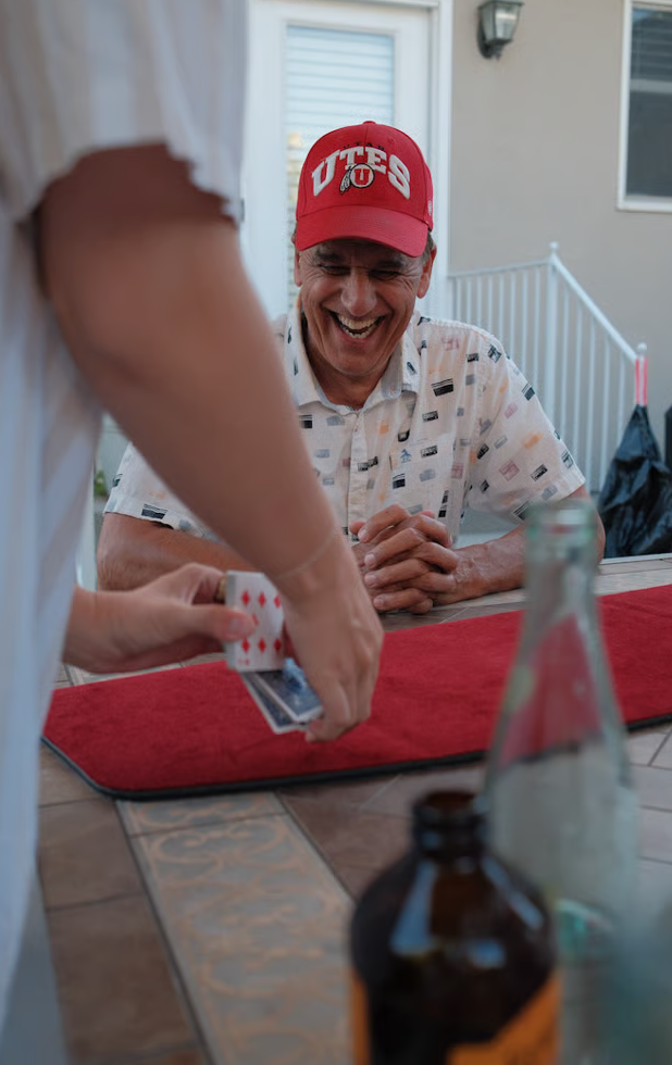 A guest laughing during a close-up card magic performance