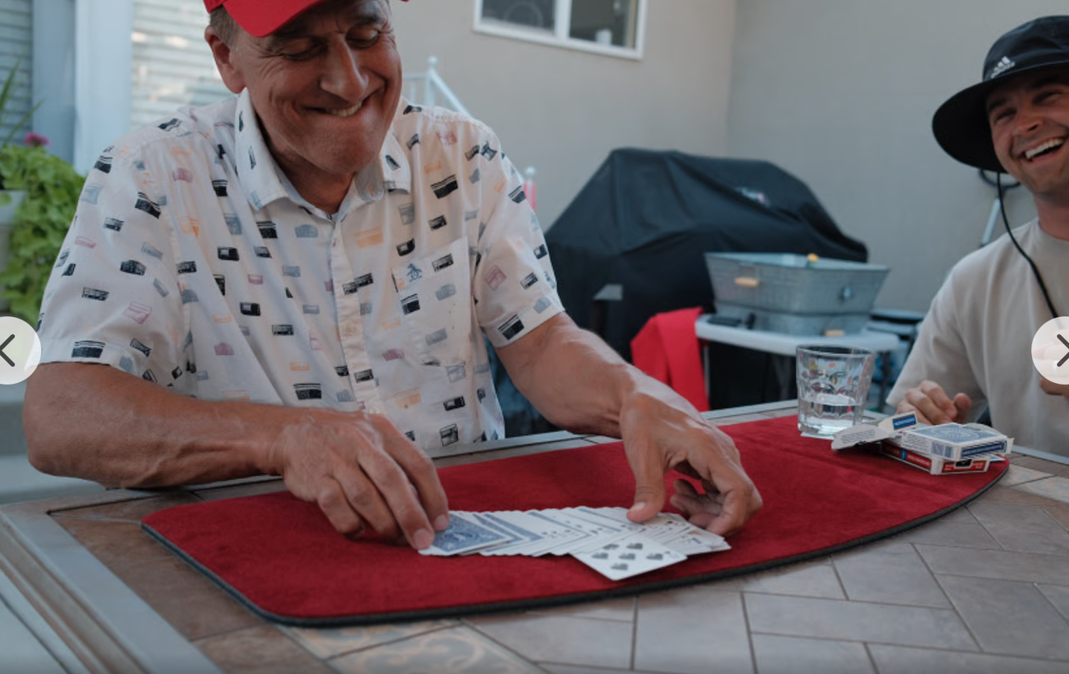 Jim smiling as he performs close-up card magic at a table